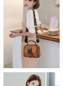 Detail of brown textured leather handbag featuring a stylish patterned wide shoulder strap