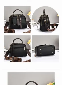 Detail showing litchi grain texture, bottom rivets and pattern strap on black handbag