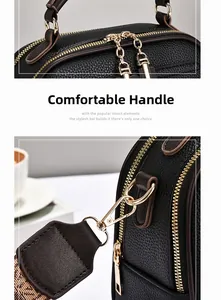 Detail view of black litchi pattern leather bag with gold zippers and jacquard strap