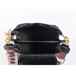 Internal double compartment view of black crossbody bag with wide logo strap and pompom