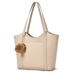 Minimalistische beige Leder-Tote-Bag mit braunem Löwenanhänger und langen Schulterriemen