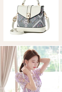 Detailed view of cream-colored handbag featuring a golden bear lock and knit pattern texture