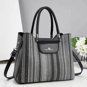 Striped woven handbag with black leather flap and tassel, shown from a front perspective