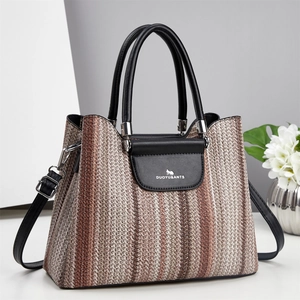 Striped woven handbag with black leather handles and crossbody strap for women