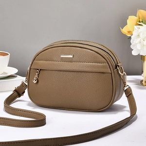 Sac bandoulière marron en cuir grainé avec double fermeture éclair et finitions dorées