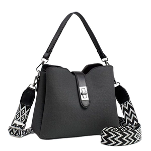 Chic dark woven bucket bag with leather handles and geometric patterned wide shoulder strap