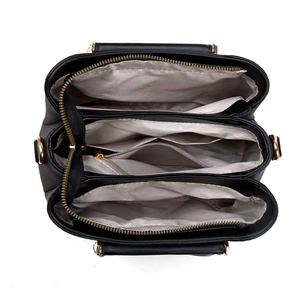 Detailed interior of black tote bag showing three compartments and herringbone lining