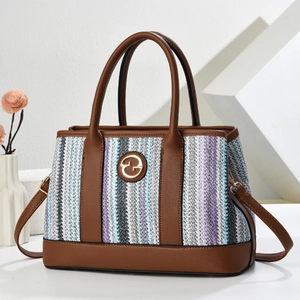 Striped woven tote bag with brown leather trim and golden logo on geometric background