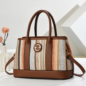 Chic multi-color striped bucket bag with brown leather handles and a gold logo accent