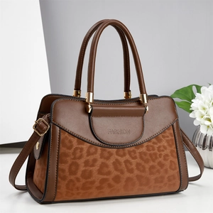 Detail of brown leopard print panel and golden hardware on the women handbag