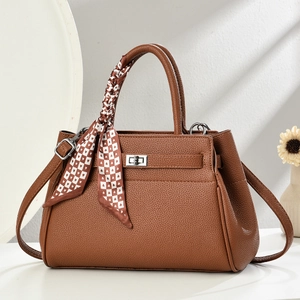 Deep brown litchi leather tote bag with silver twist lock and decorative scarf on handle