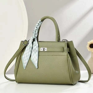 Detail of olive green leather handbag with lychee texture and decorative silk scarf