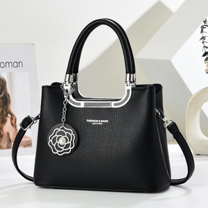 Detail of black lychee grain leather handbag with pearl camellia charm and silver hardware