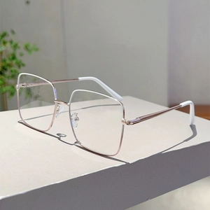 Détail de la monture de lunettes carrée en métal or rose avec accents blancs