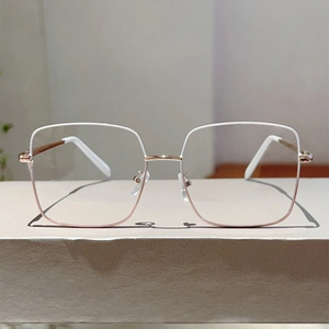 Détail de la monture de lunettes carrée en métal avec finition bicolore et charnières à ressort