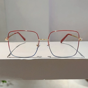 Vue de face de lunettes carrées dégradé rouge et bleu avec branches en métal doré