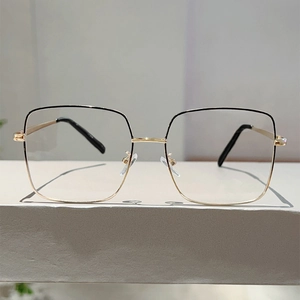 Détail de la monture de lunettes carrée noire et dorée avec charnières à ressort flexibles