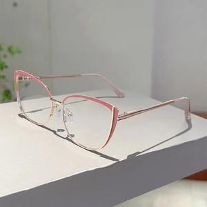 Detail view of pink cat-eye glasses with rose gold metal frames on a display stand