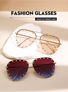 Detail of pilot sunglasses with rivet accents and gradient pink and blue lenses