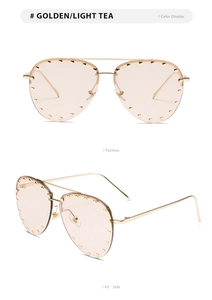 Detail view of gold aviator sunglasses with studded lenses and metallic frame