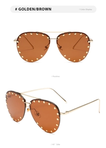 Detail of pilot sunglasses with golden metal frame, brown lenses and studded accents
