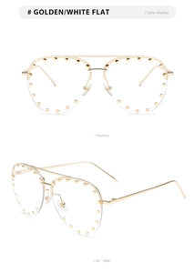 Detail view of gold aviator sunglasses with studded metal frames and clear lenses