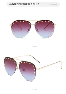 Close-up of aviator sunglasses with gold frames, purple gradient lenses, and rivet details