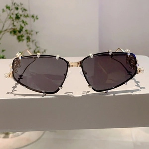 Makrodetail der Y2K Sonnenbrille mit funkelnden Strasssteinen auf goldenem Metallrahmen