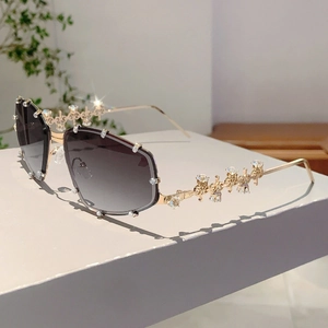 Detailansicht goldener Metallbügel und kristalbesetzter Ränder an der Sonnenbrille