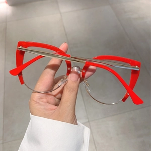 Detail of red cat-eye glasses with gold metal bridge and half-rim frame design
