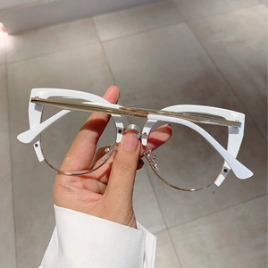 Detail of half-rim cat eye glasses with bold white top frame and gold metal accents