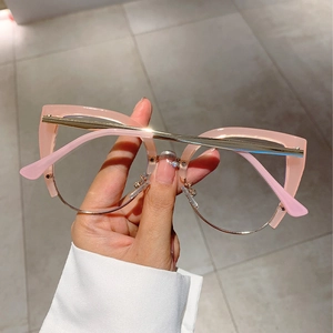 Detail view of pink cat-eye half-frame glasses with gold metal and semi-transparent rim