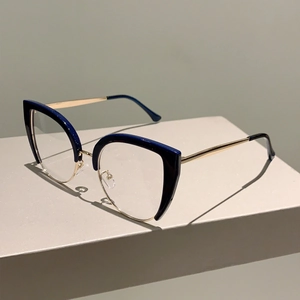 Detail of cat-eye glasses frame with blue half-rim and golden metal temples on a stand
