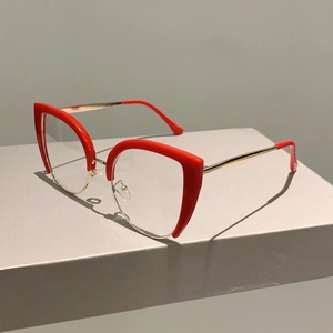 Detail of red cat-eye half-frame glasses with gold metal wire and matching red temple tips