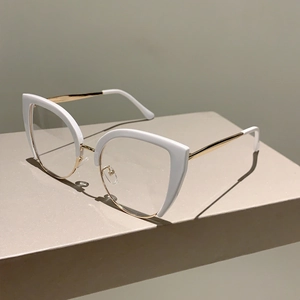 Detail of half-rim cat eye glasses with white acetate upper and gold metal frame