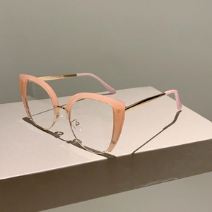 Detail of pink semi-rimless cat-eye glasses with gold metal temples on a geometric base