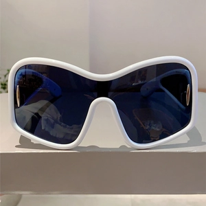 Detail of white oversized Y2K sunglasses with gold vertical metal accents and dark lenses