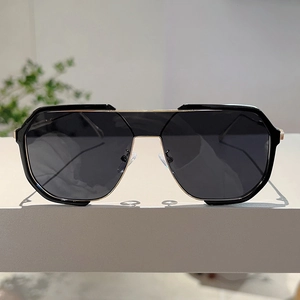 Detail of oversized geometric sunglasses with black frame and golden metal accents