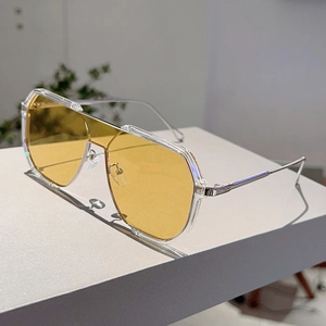 Detailed view of silver metal frames and yellow lenses on modern oversized sunglasses