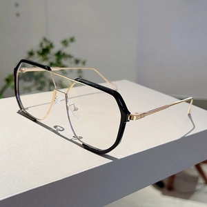 Detail view of oversized geometric black and gold frame sunglasses on a display stand