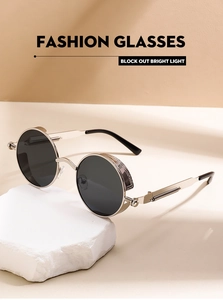 Detail of silver steampunk sunglasses with side shields on white stone base