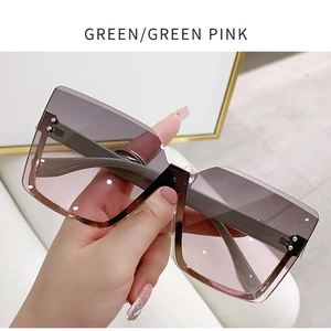 Close-up of frameless gradient sunglasses with gold metal rivets and pink tint lenses