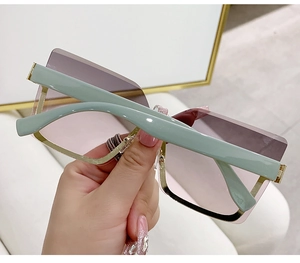 Detail of rimless square sunglasses with pink-purple gradient lenses and mint green temples