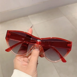 Detail of red transparent oversized sunglasses featuring gradient lenses and unibody frame