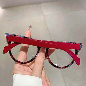 Detail der floralen Rahmen mit roten Bügeln an der stylischen Cat-Eye-Brille im Retrostil