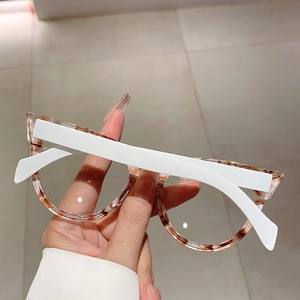 Detail der Katzenaugenbrille mit braunem Schildpatt-Rahmen und weißen Bügeln