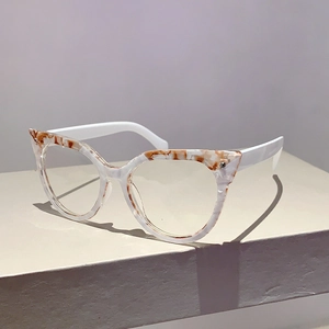 Detail der Katzenaugen-Brillenfassung mit Marmormuster und weißen Bügeln im Display