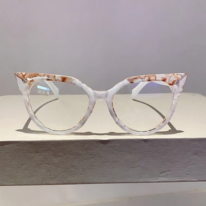 Detail der Cat-Eye Blaulichtfilter-Brille mit bernsteinfarbenem Gestell auf Stein