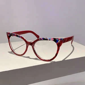 Nahaufnahme der Cat-Eye-Brille mit leuchtend rotem Rahmen und floralen Musterakzenten