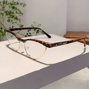 Detail of retro cat-eye glasses with tortoise frames and golden metal rims on stand